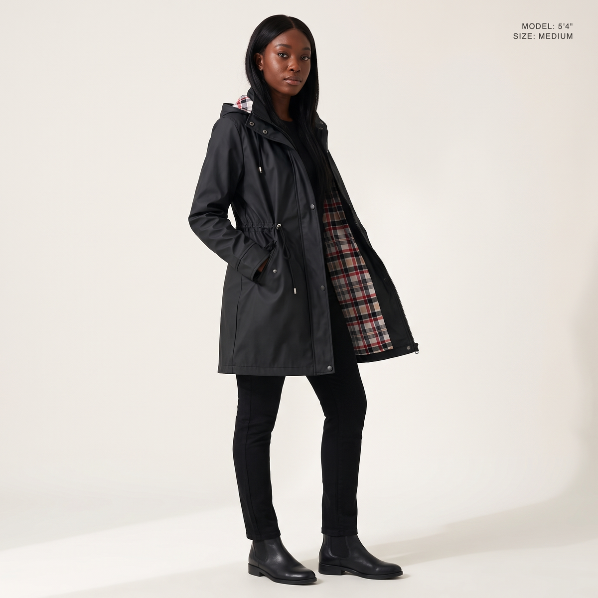 The Ashby Hooded Rain Trench in Black, worn open to show the plaid flannel lining, model 5 foot 4 wearing size Medium