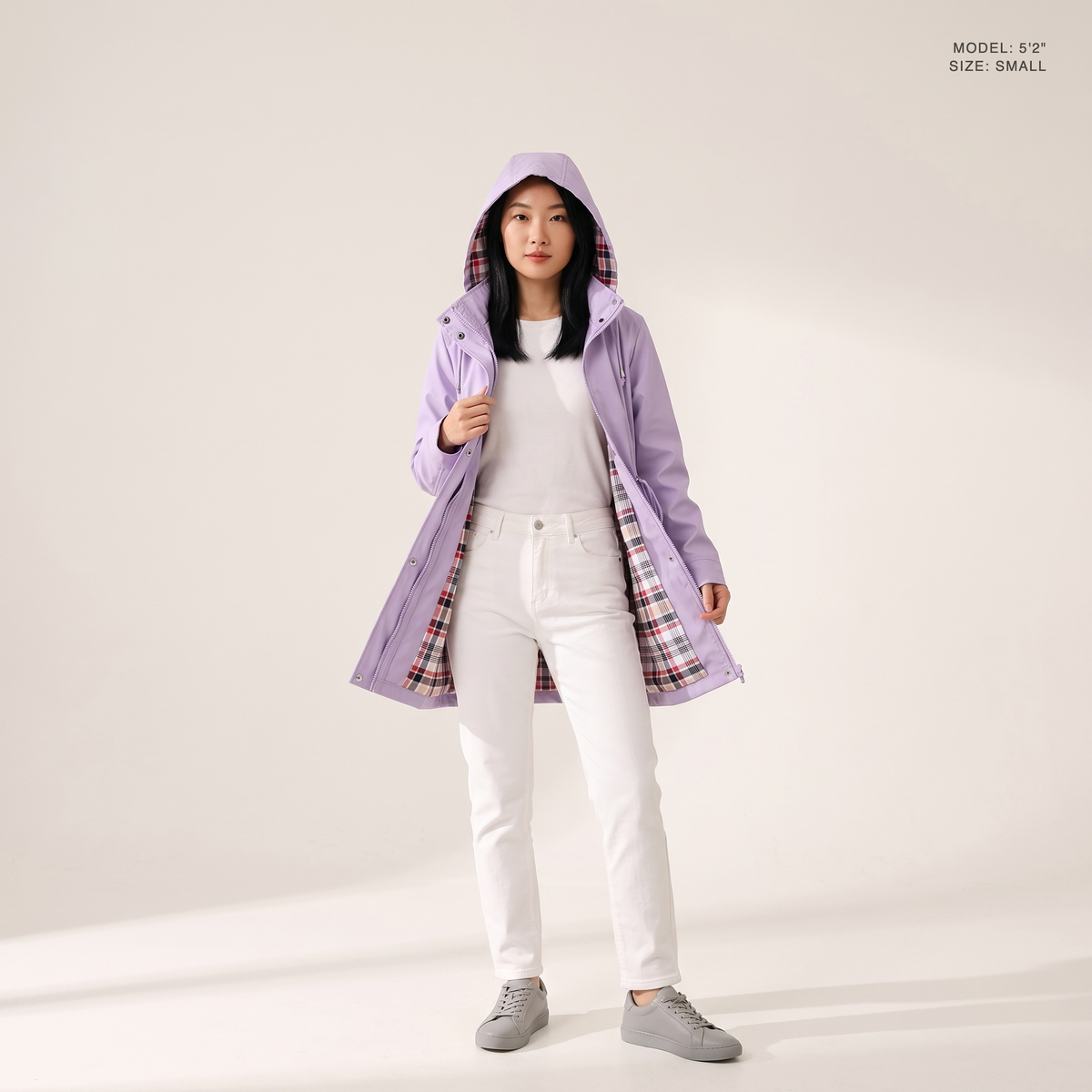 The Ashby Hooded Rain Trench in Violet, hood up and worn open to show the plaid flannel lining, model 5 foot 2 wearing size Small
