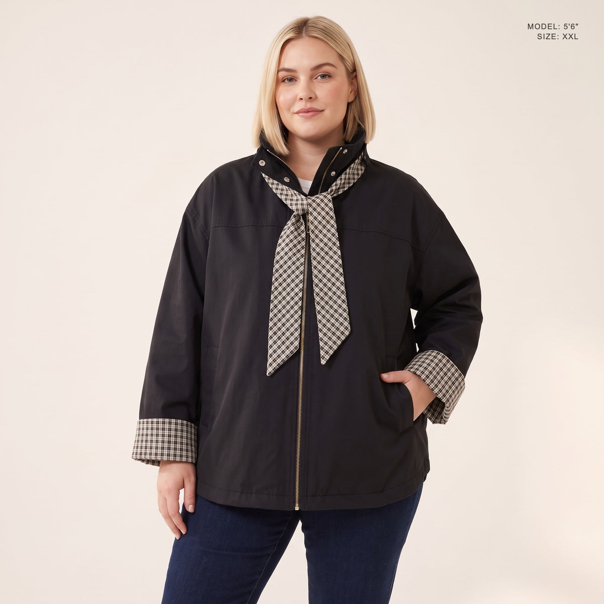 The Hartley Hooded Windbreaker in Black with the plaid scarf knotted at the collar, model 5 foot 6 wearing size XXL