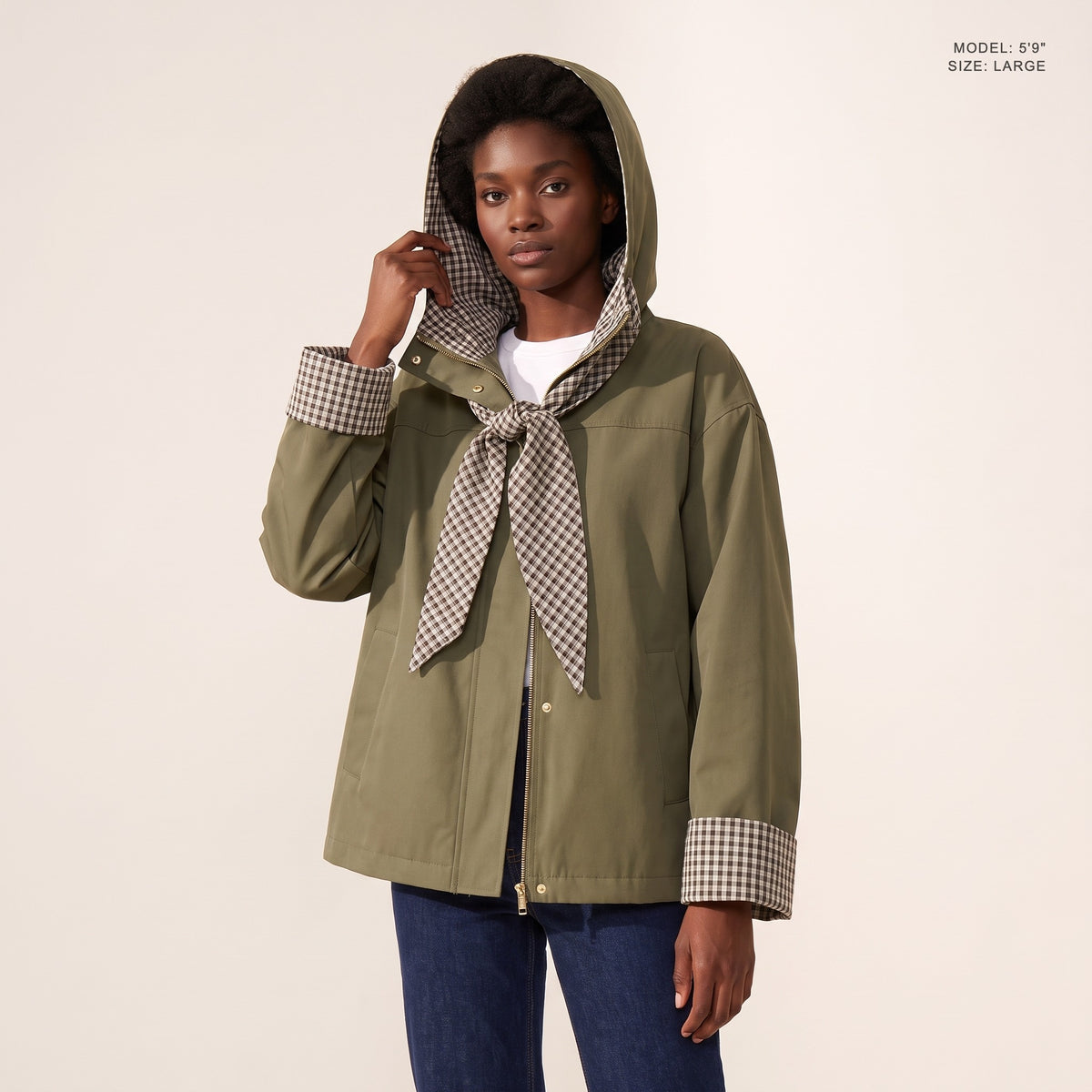 The Hartley Hooded Windbreaker in Olive, hood up with the plaid scarf tied at the throat, model 5 foot 9 wearing size Large